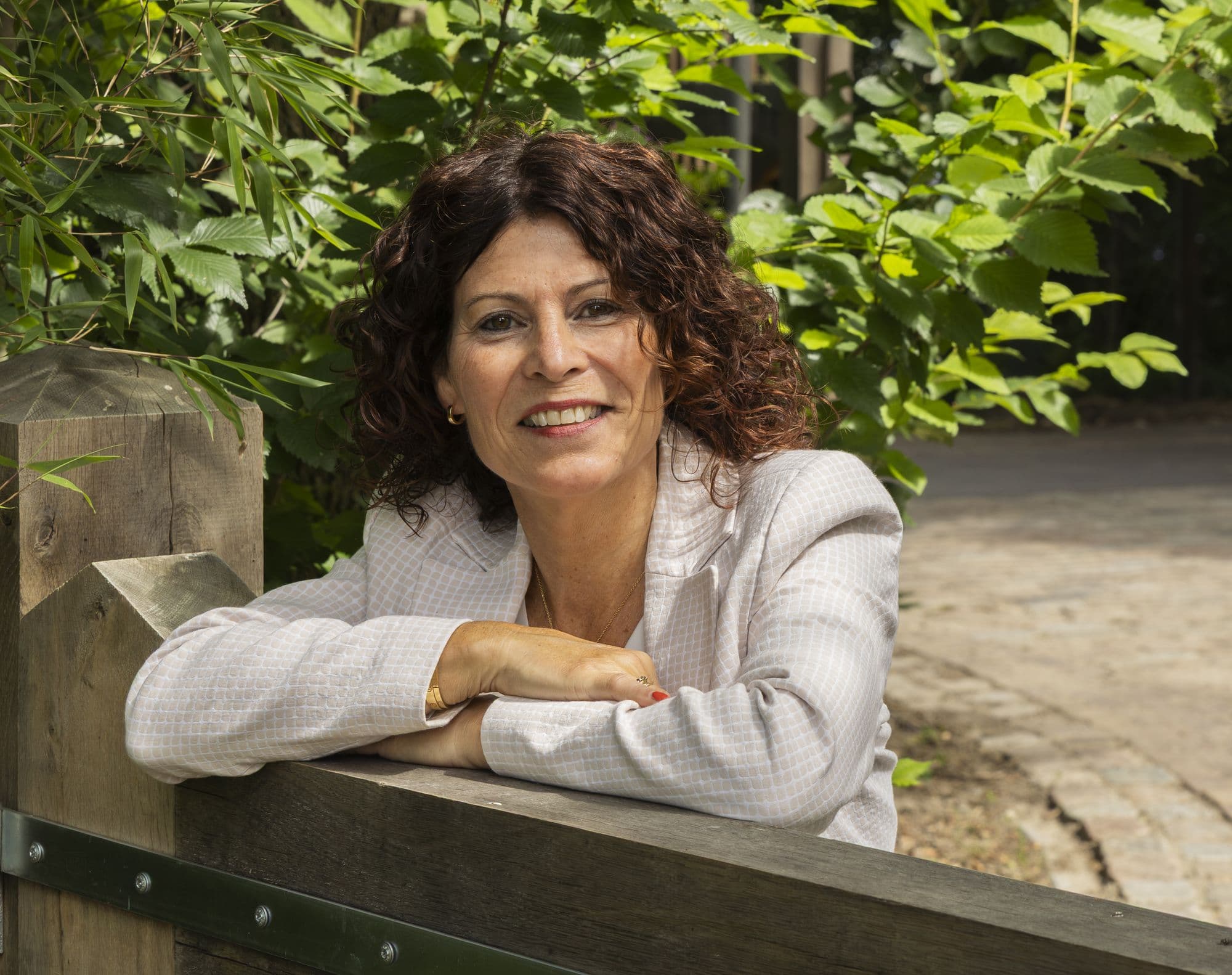 Jeanine, vertrouwenspersoon bij Confidence Talk, leunend op een houten hek
