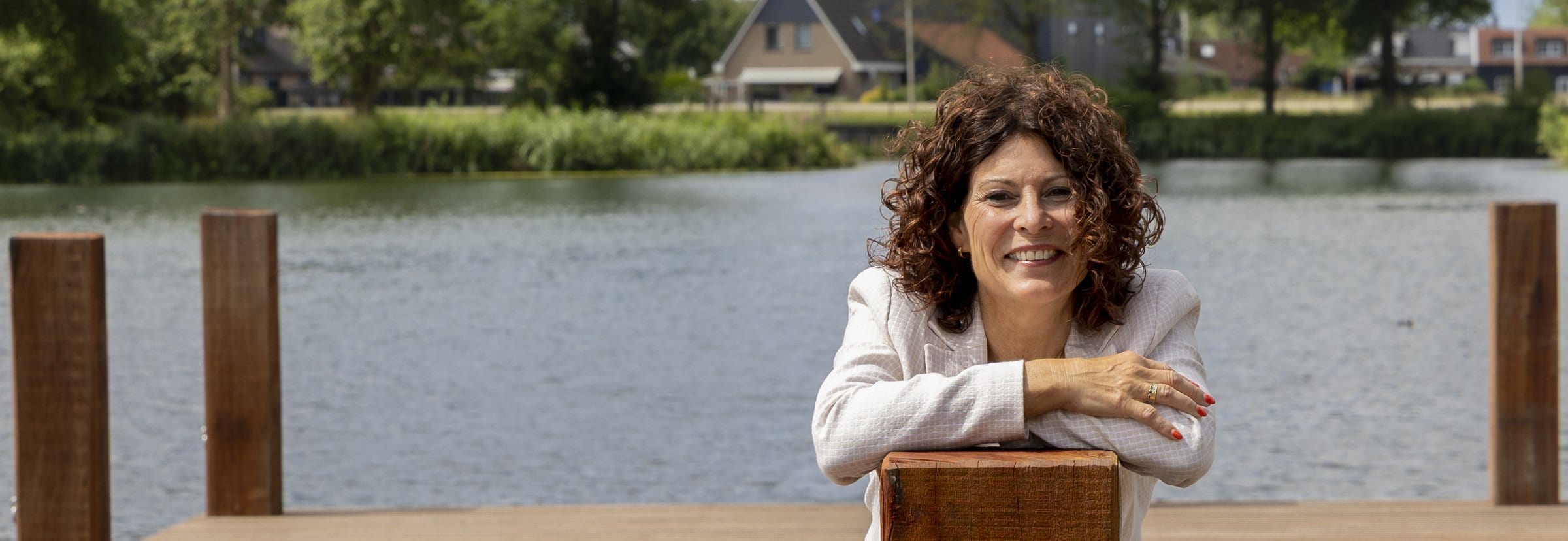 Jeanine, vertrouwenspersoon bij Confidence Talk, leunend op een paal van de steiger