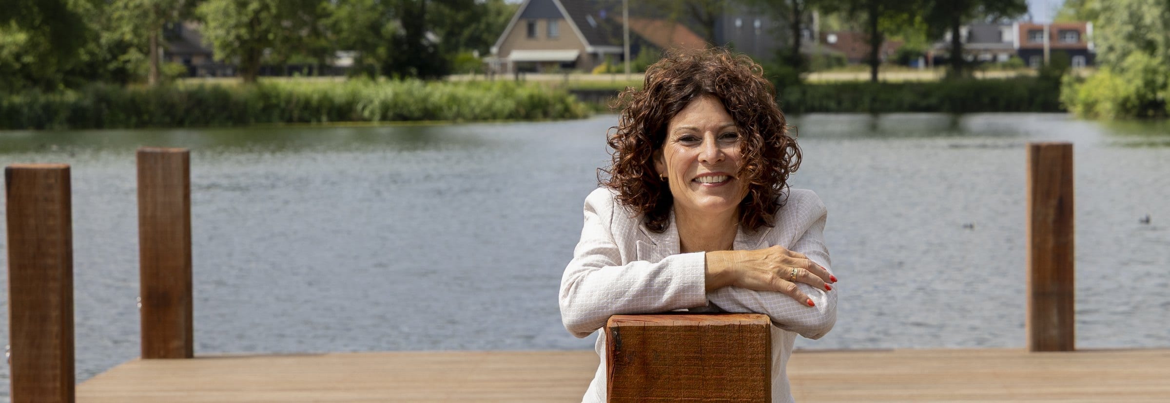 Jeanine, vertrouwenspersoon bij Confidence Talk, leunend op een paal van de steiger