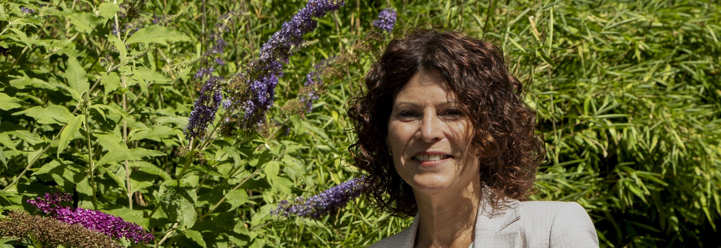Jeanine, vertrouwenspersoon bij Confidence Talk, bij een bloeiende vlinderstruik