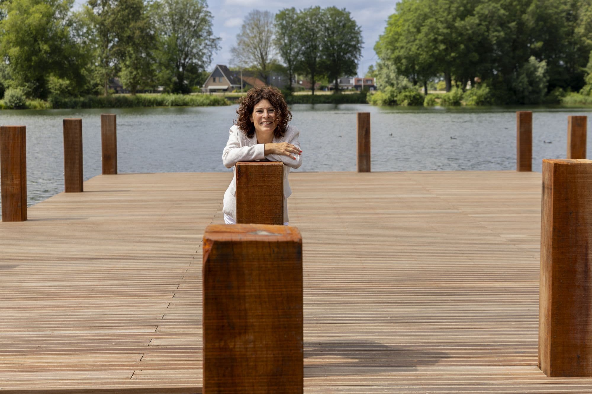 Jeanine, vertrouwenspersoon bij Confidence Talk, leunend op een paal van de steiger